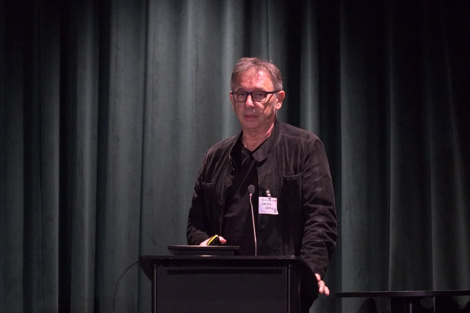 Dean Skira speaking at the lectern at Circular Lighting Live 2026 in London